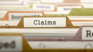 Filing cabinet with a focused folder labeled "Claims," others blurred behind.