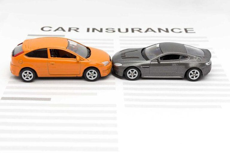 Orange and gray toy cars face each other on a car insurance document.