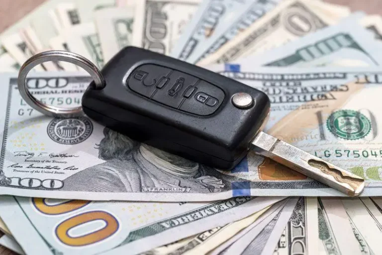 Car key fob with metal blade on stack of 0 bills.
