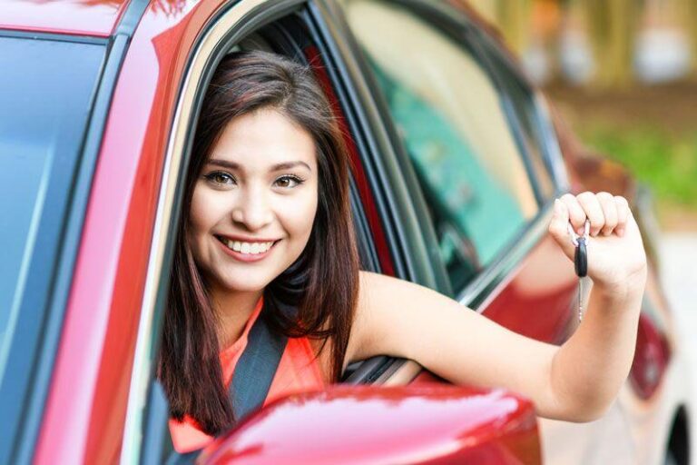 Woman smiling in red car, holding a car key out the window. Woman smiling in red car, holding a car key out the window.